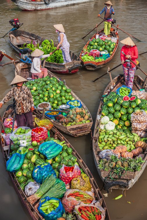 Vietnamesische Frauen, die Obst auf dem schwimmenden Markt, Mekong River Delta, Vietnam verkaufen.symbolisiert Rundreisen